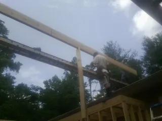 Carpenter setting a ridge beam over a new addition frame — Ice Dam Removal by Roofing Brothers in Woodstown