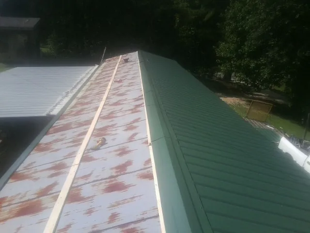 Old rusted panels beside newly installed green metal roofing — Wind Damage Roof Repair by Roofing Brothers in Woodstown