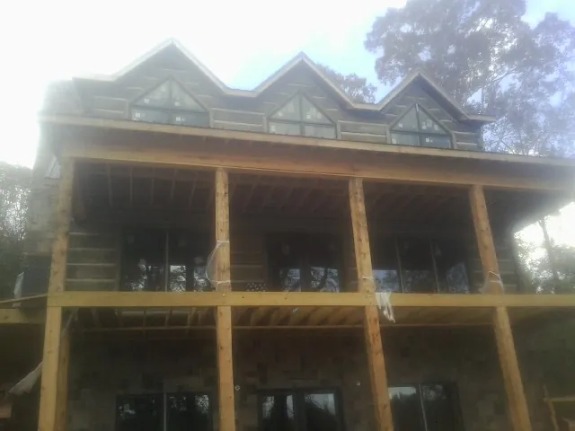 Dormers and porch framing on a large log home under construction — Roof Coating work by our crew in Woodstown